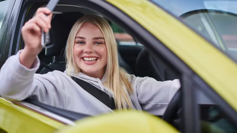 Happy new car owner holding up her keys
